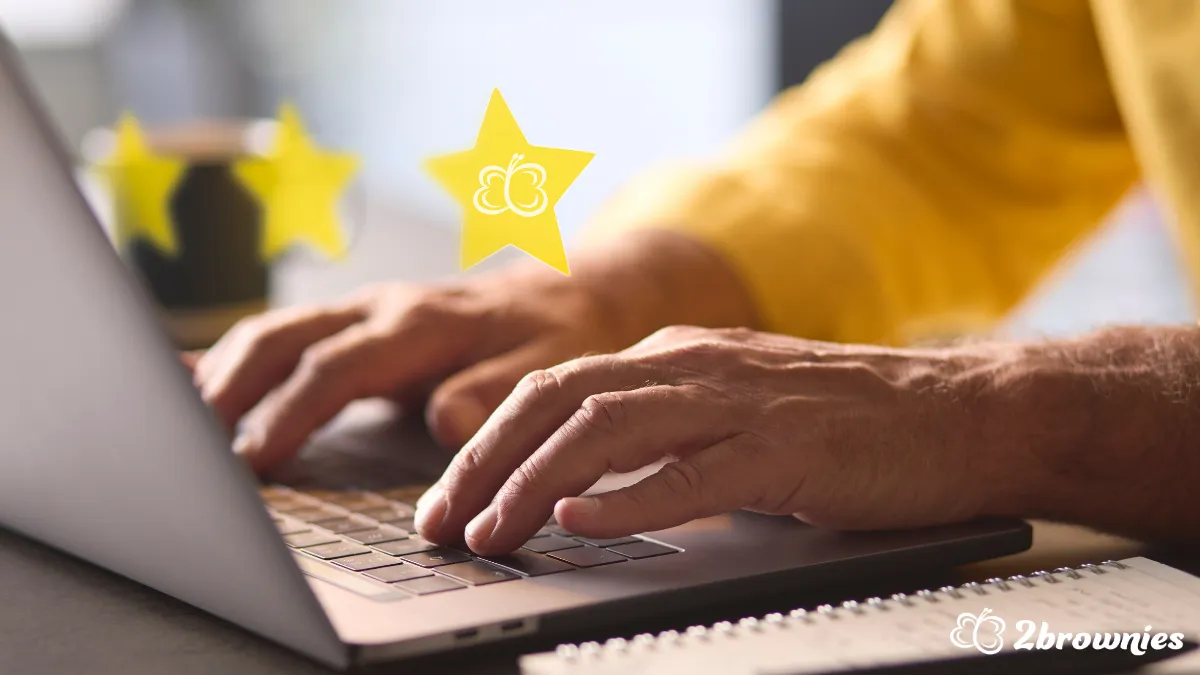 Hands typing on a laptop with yellow stars floating above